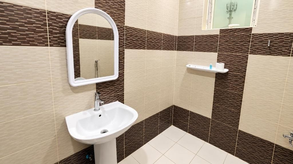 Un baño con un lavamanos blanco, un espejo y una zona de ducha.