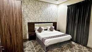 A hotel room with a bed, a wardrobe, a patterned carpet, and a ceiling with recessed lighting. - Razan Home 1 for serviced apartments (Riyadh)