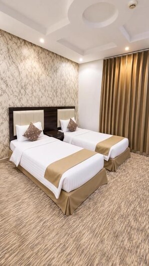 A hotel room with two beds, a marble wall, a wooden headboard, and a curtain. - Razan Home 1 for serviced apartments (Riyadh)