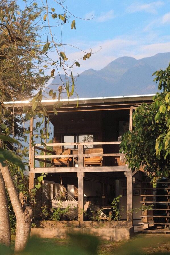 A wooden cabin with a balcony overlooking a mountainous landscape.