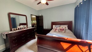 A bedroom with a wooden bed, a dresser, a ceiling fan, and a mirror. - Ultimate private 4 bedroom 3 full bathrooms right next to golf course with path (Lewisport)