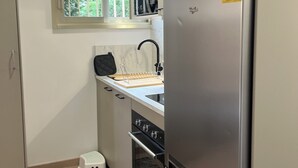 A compact kitchen with a refrigerator, oven, and a window above the sink. - Apartment Cannes garden 5mn close to downtown 5mm Gare plages Croisette (Cannes)