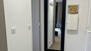 A hallway with a coat rack, a mirror, and a utility box. - Apartment Cannes garden 5mn close to downtown 5mm Gare plages Croisette (Cannes)