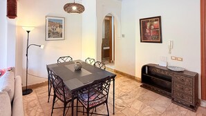 A dining area with a table and chairs, a floor lamp, and a decorative console table with a plate. - 2-bed Apartment with Garden & shared Pool- Moroccan - Modern Style (Marrakech)