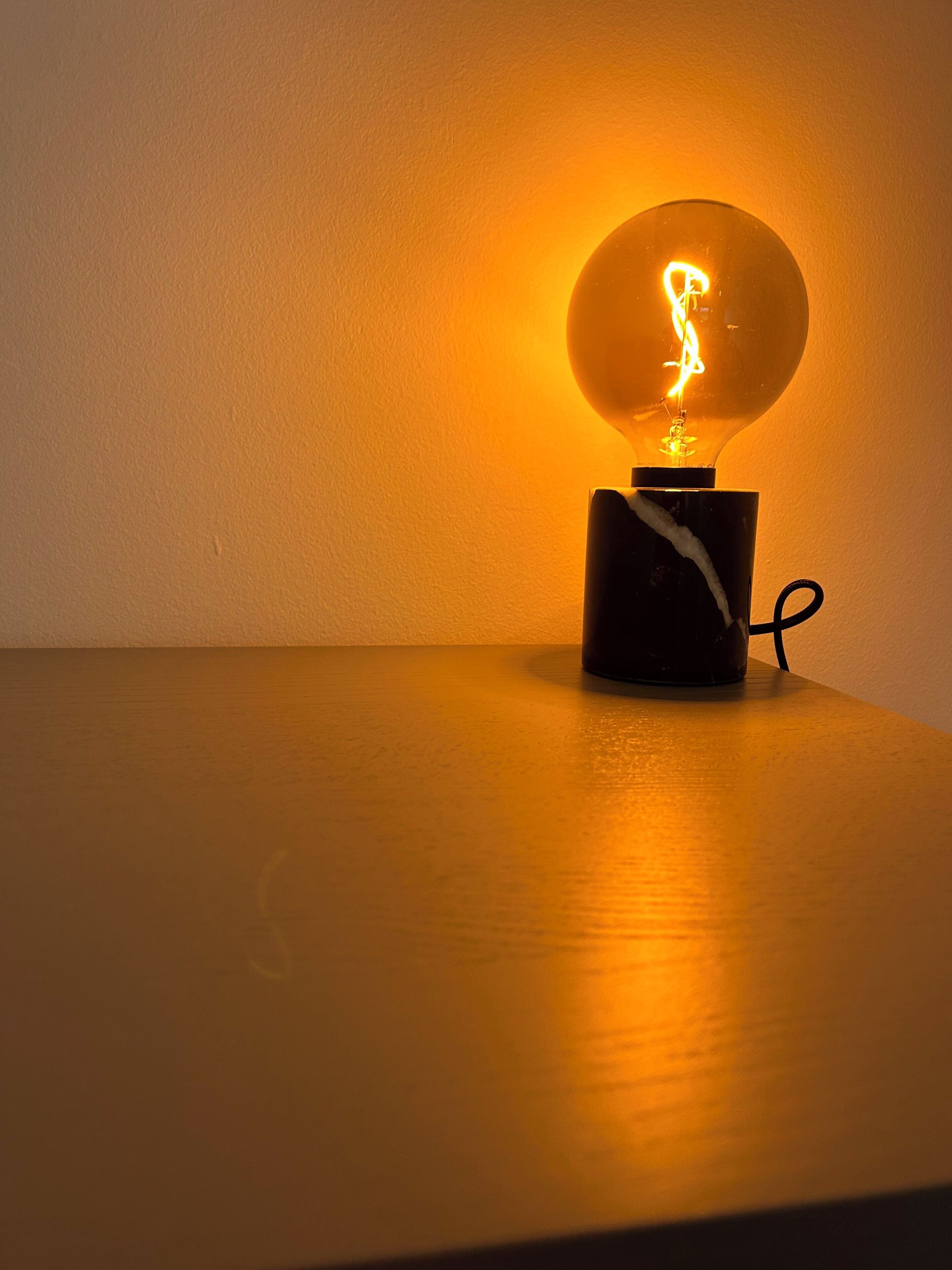 A table with a spherical light fixture emitting a warm glow.