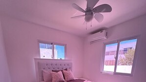 A bedroom with a bed, nightstand, and ceiling fan. - 3-bedroom house in delightful Punta Cana with AC (Punta Cana)