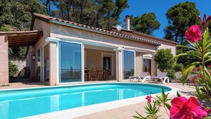 A poolside villa with a covered patio, a swimming pool, and a garden with pink flowers. - House with swimming pool and beautiful view (Lédenon)