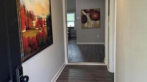 A hallway with wooden flooring, a painting on the left wall, and a door on the right. - High falls Lakefront Dock, Dock, Lake Views & Game Room (Jackson)
