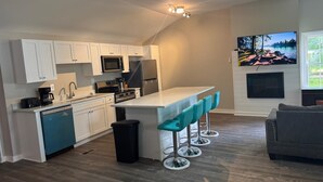A modern kitchen with white cabinets, a central island with bar stools, a built-in oven, and a ceiling fan. - High falls Lakefront Dock, Dock, Lake Views & Game Room (Jackson)