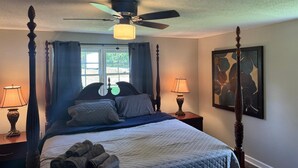 A four-poster bed with a ceiling fan, two bedside lamps, and a painting on the wall. - High falls Lakefront Dock, Dock, Lake Views & Game Room (Jackson)
