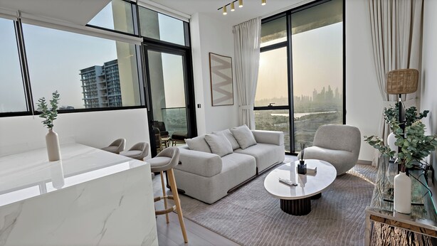 A modern living room with a sofa, armchairs, a coffee table, and a view of a cityscape through large windows. - Private Pool | Movies in bed | No Camels (دبي)