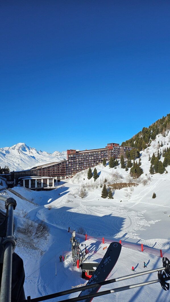 Ein Skigebiet mit einem großen Gebäude, Skiliften und verschneiten Pisten.