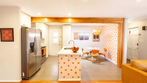 Una cocina moderna con un refrigerador de acero inoxidable, un horno empotrado y una isla central con un lavamanos.