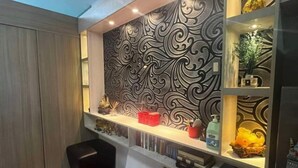 Une chambre moderne avec un mur orné de motifs, un tapis rouge et une étagère décorative.