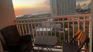 Un balcon offrant une vue sur le paysage urbain au coucher du soleil.