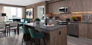 A modern kitchen with a central island, stainless steel appliances, and wooden cabinetry.