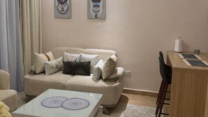 Una sala de estar con sofá, mesa de centro, escritorio y una silla.