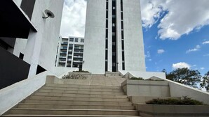 Una serie de escalones de hormigón que conducen a un edificio moderno con techo plano y varios ventanales.