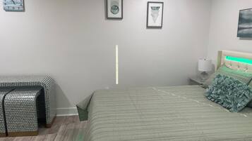 Une chambre à coucher avec un lit, des tables de chevet, une commode et une horloge murale.