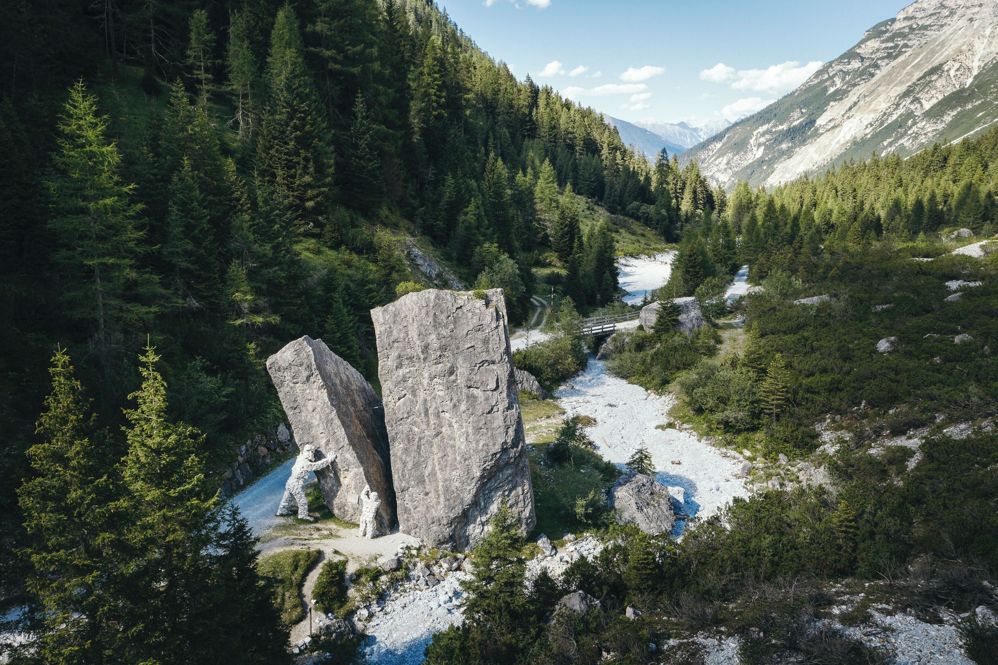 A mountainous landscape with a prominent rock formation and a river.