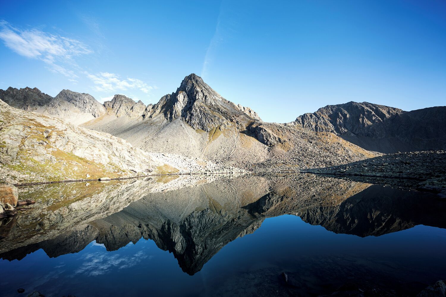 Un paysage de montagne se reflétant clairement dans un lac paisible.