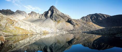Un paysage de montagne se reflétant clairement dans un lac paisible.