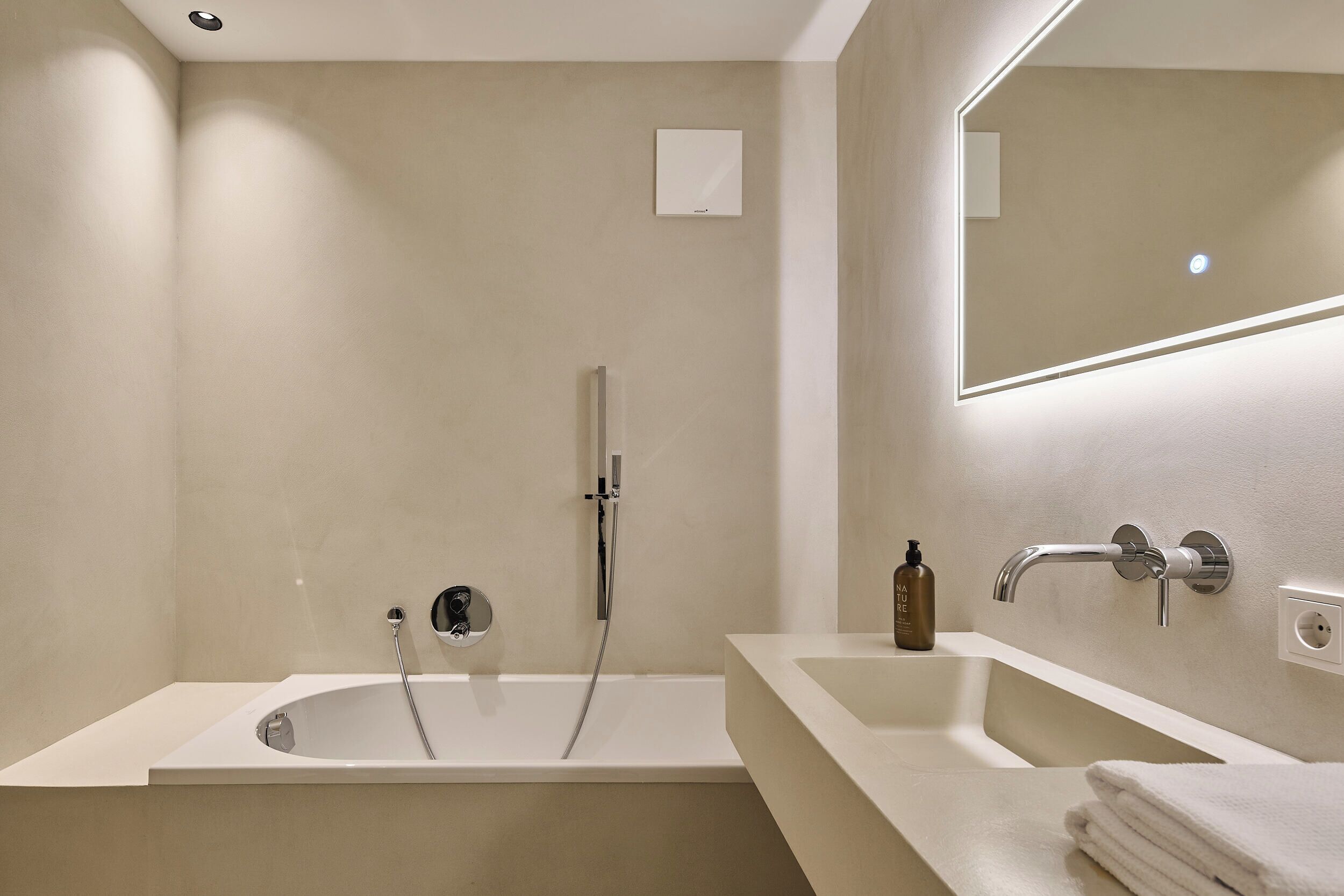 A modern bathroom with a freestanding bathtub, a double sink, and a mirror above the sink.