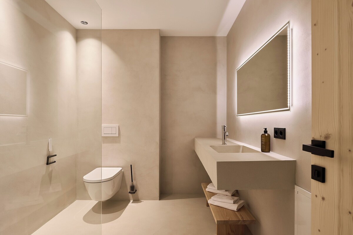 Une salle de bain moderne avec des toilettes, un lavabo et un miroir.