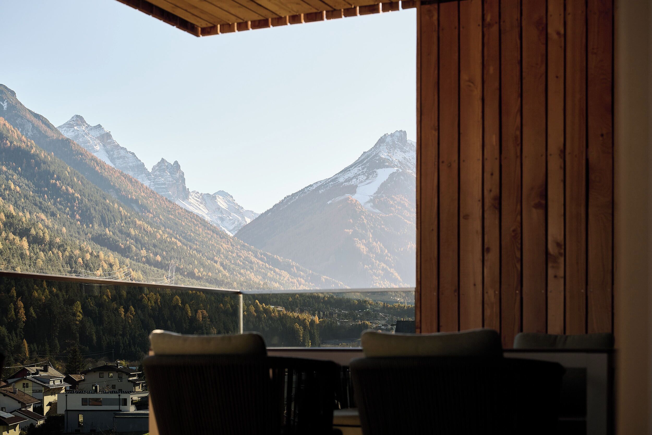 A balcony with a view of mountains and a town below.