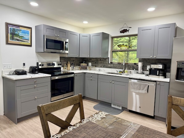 A modern kitchen with grey cabinets, a microwave, a coffee maker, and a dishwasher.