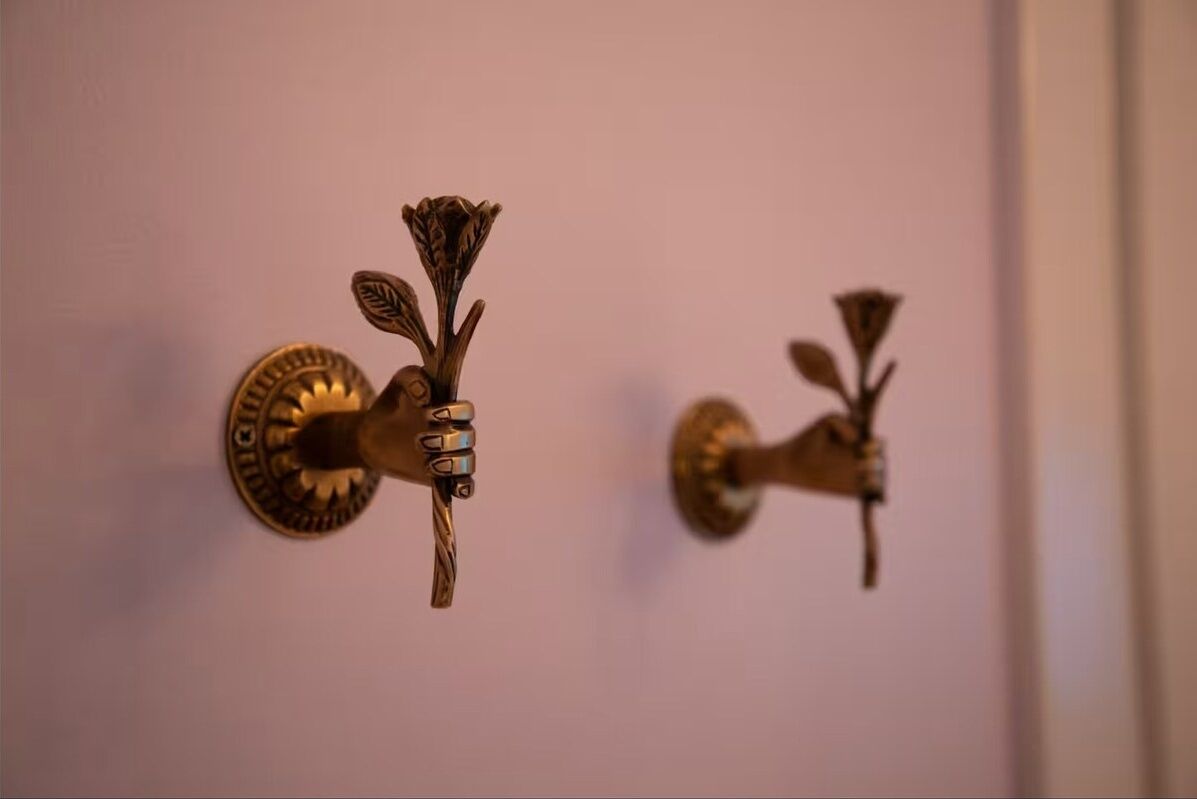 Dos manijas de bronce con diseños florales.
