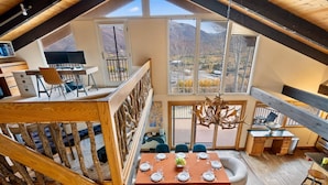 Un loft espacioso con comedor, cocina y un balcón con vista a la montaña.