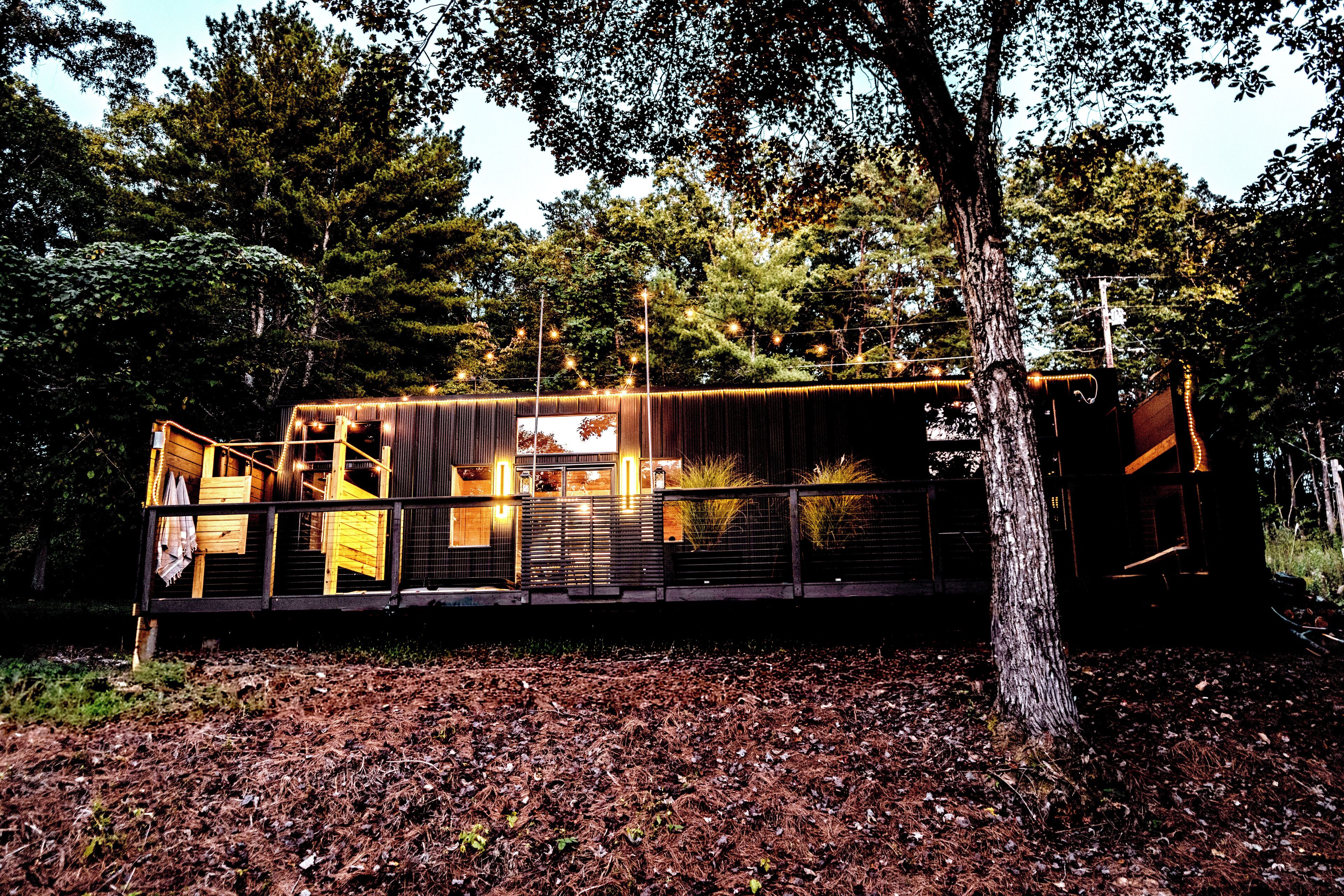 Un chalet rustique aux murs en bois, entouré d’arbres.