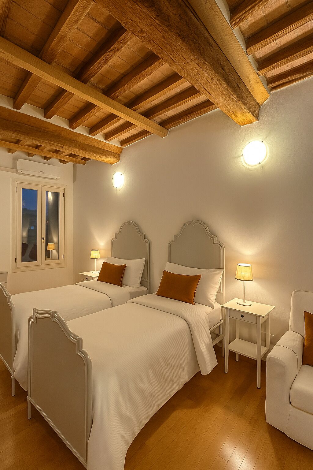 Une chambre d’hôtel avec deux lits, des poutres apparentes en bois au plafond, une fenêtre avec vue et des lampes de chevet.