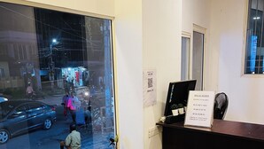 A reception desk with a sign indicating room availability and a QR code. - Regal Suites (Thiruvananthapuram)