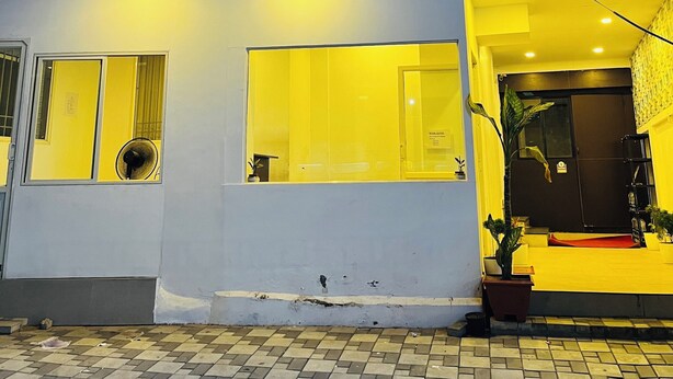 A hotel named Regal Suites with a signboard, large windows, and a yellow entrance. - Regal Suites (Thiruvananthapuram)