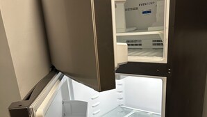 Un réfrigérateur ouvert, doté de plusieurs étagères et d’un compartiment congélateur.