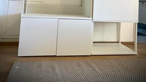 Quarto minimalista com guarda-roupa embutido, um pequeno espaço de estar e um cabideiro.