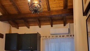 A cozy kitchen with dark cabinets, a built-in oven, and a dining area with a round table and chairs. - XISTO Xisto, a haven for an unforgettable stay. (Semide)