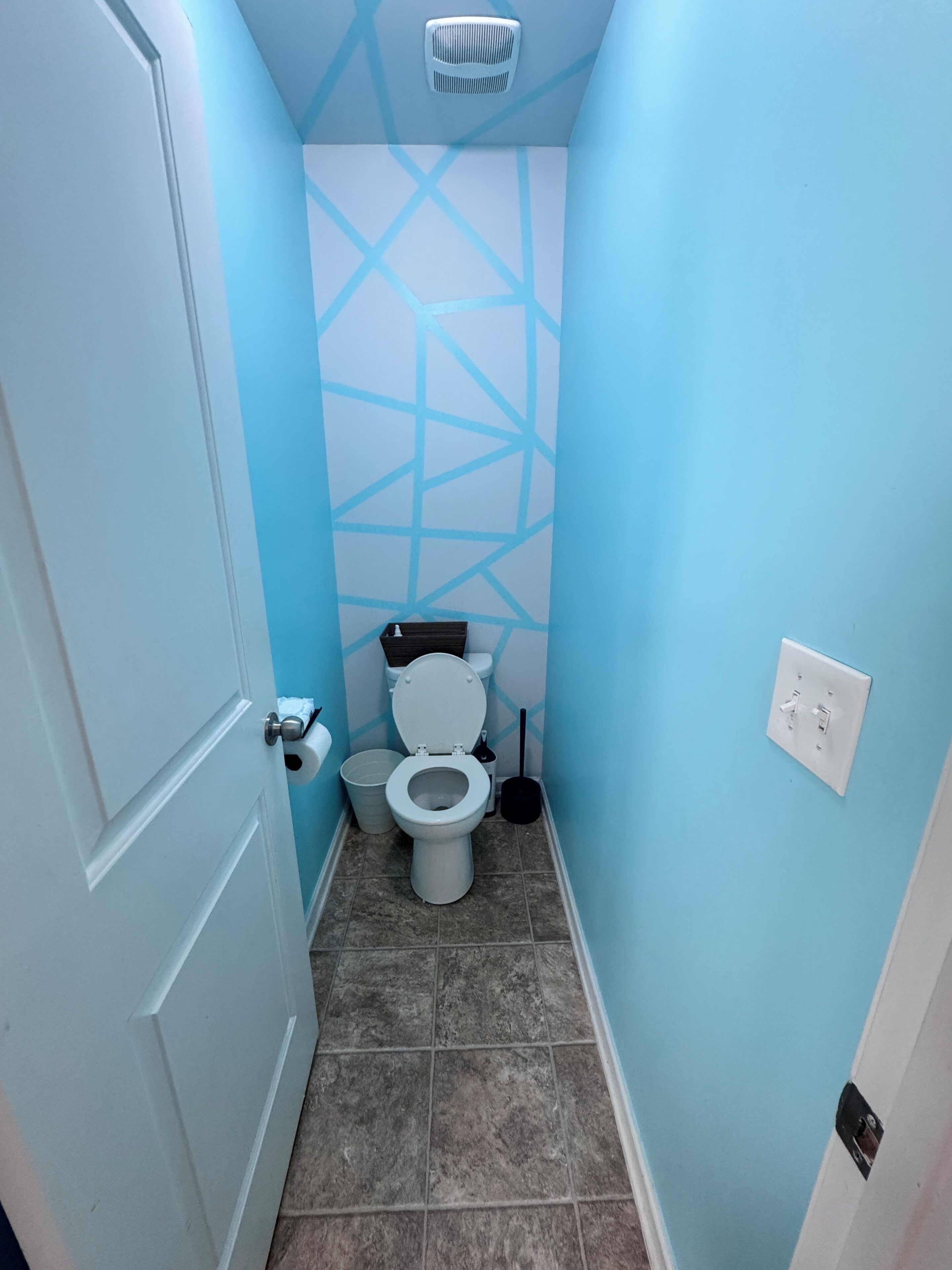 Ein kleines Badezimmer mit Toilette, Mülleimer und Wandheizung.