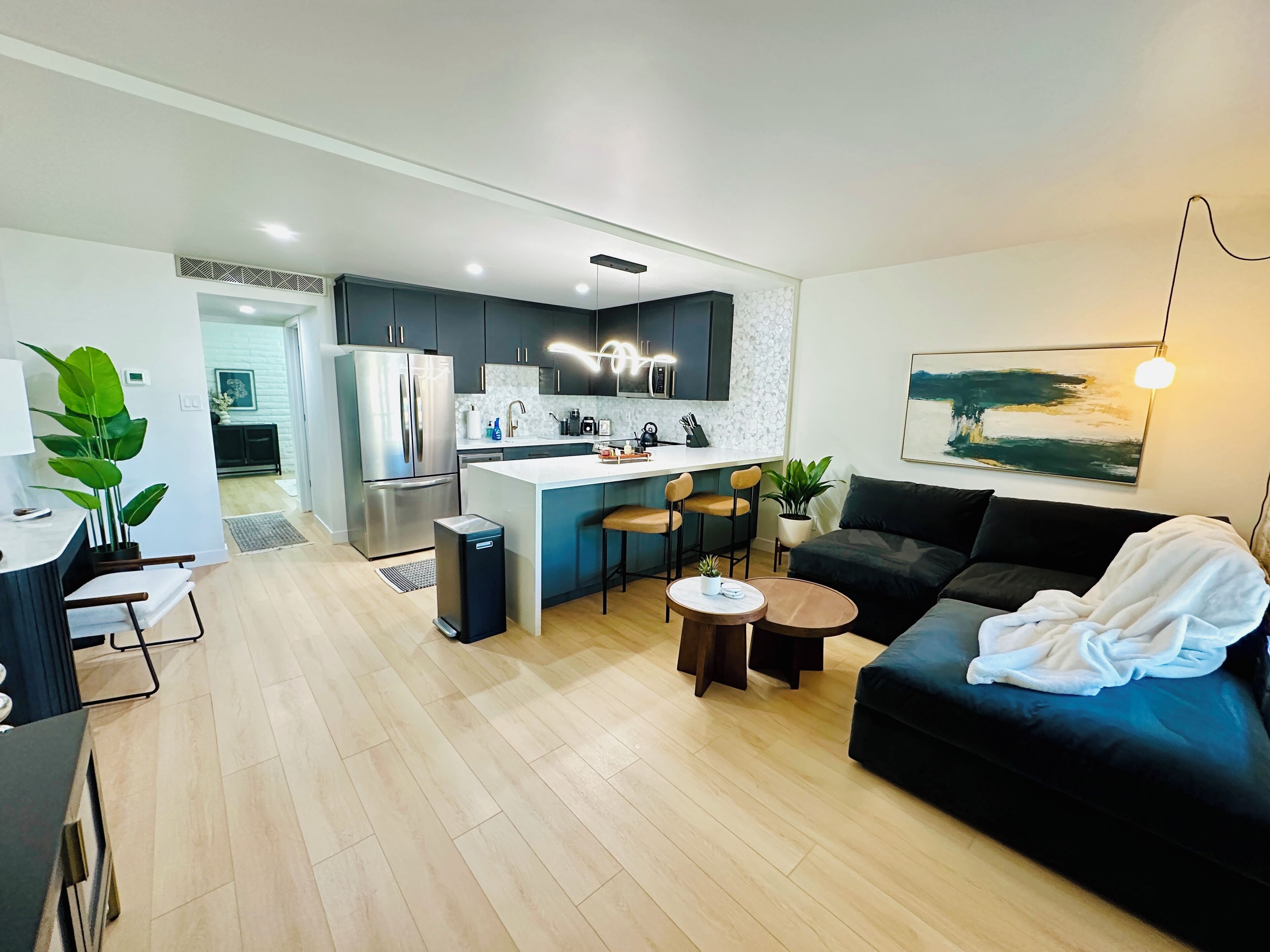 A modern apartment with a kitchen, dining area, and living room.