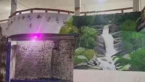 A room with a stone wall, a wooden beam ceiling, and a mural of a waterfall. - Hostal y Complejo Turistico La Rueda (Guaranda)