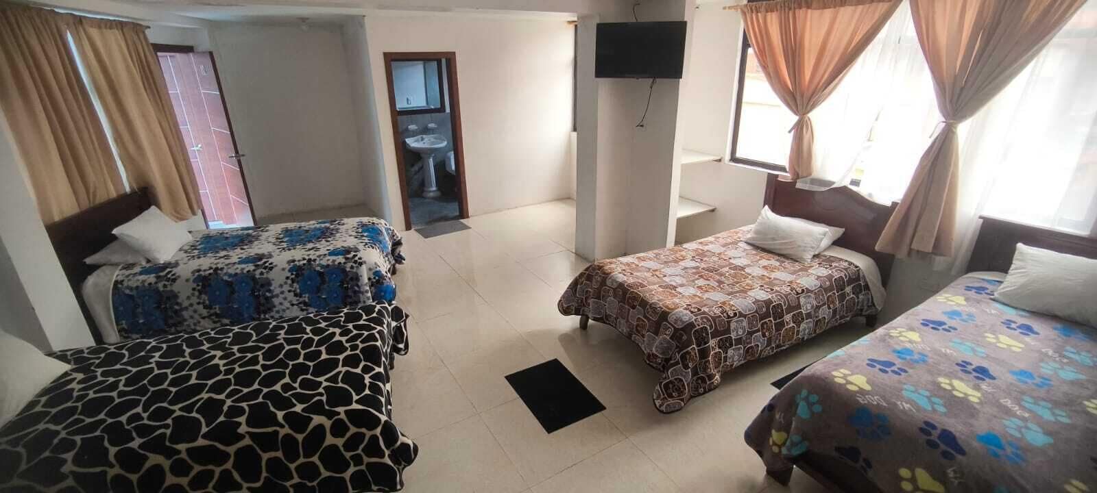 Une chambre d’hôtel avec deux lits, une télévision, une salle de bain et une vue sur l’extérieur.