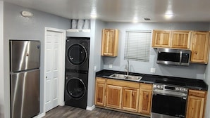 Una cocina compacta con refrigerador de acero inoxidable, horno doble, microondas y lavavajillas.