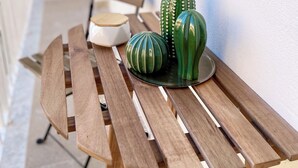 Une table en bois sur laquelle sont posés un cactus vert et un bol décoratif.