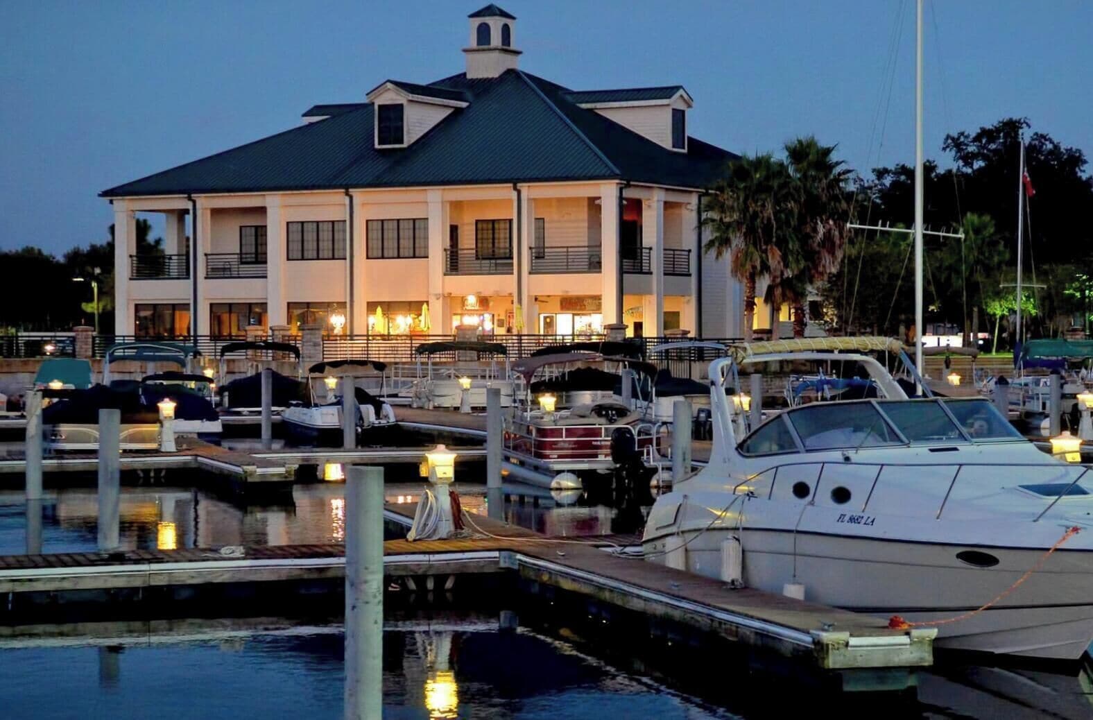 A waterfront property with a large house, marina, and boats.