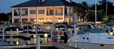 A waterfront property with a large house, marina, and boats.
