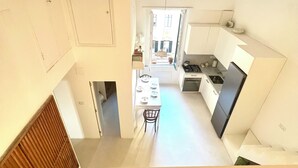 A compact kitchen with a dining area, a visible door, and a small table with chairs.