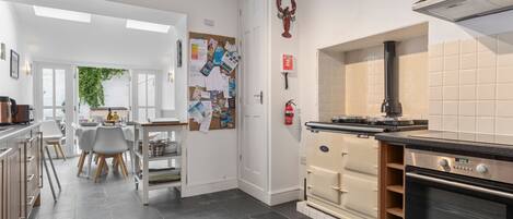 A modern kitchen with a built-in oven, a stove, and a dining area with a table and chairs.