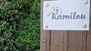 Une porte en bois avec une plaque portant l’inscription « 573 Kamilou » et une serrure.